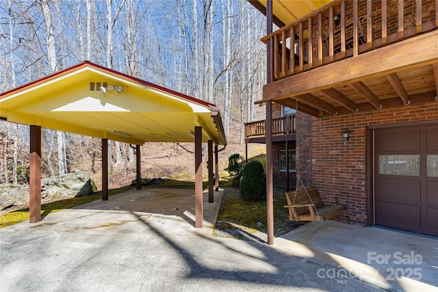 view of patio with a carport, concrete driveway, a balcony, and a garage