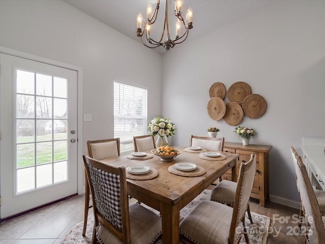 dining space with lofted ceiling, baseboards, and light tile patterned flooring