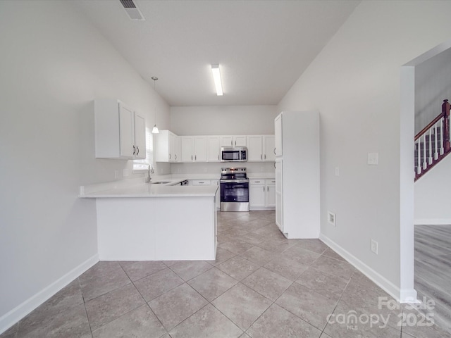 kitchen with stainless steel appliances, light countertops, a sink, a peninsula, and baseboards