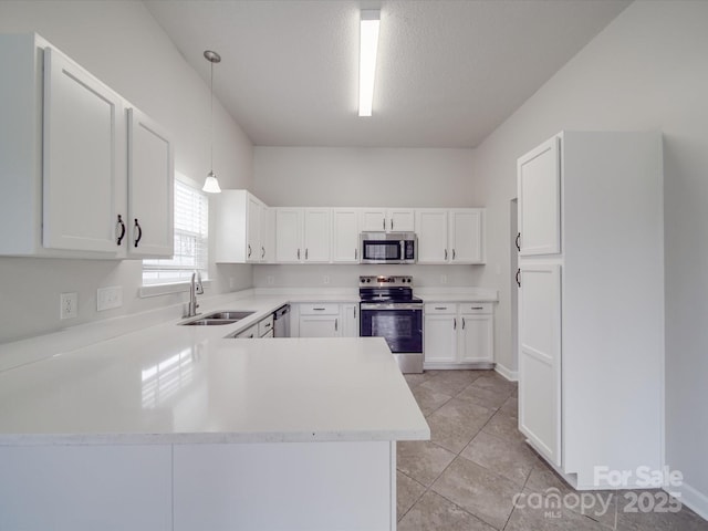 kitchen featuring decorative light fixtures, stainless steel appliances, light countertops, white cabinets, and a sink