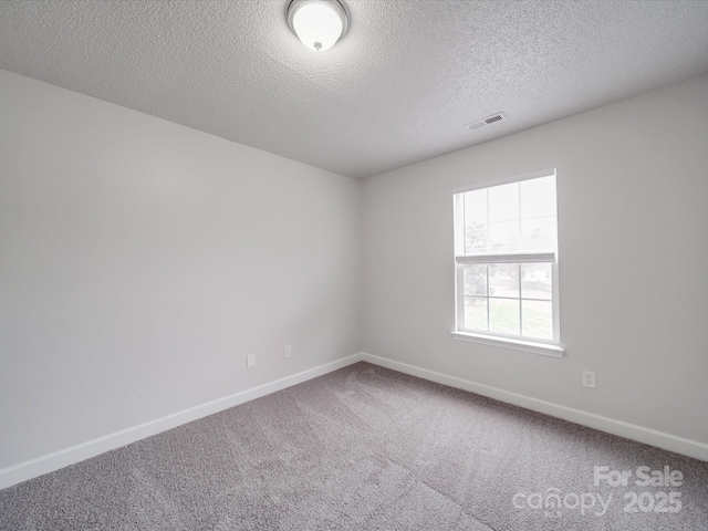 unfurnished room featuring carpet, a textured ceiling, visible vents, and baseboards