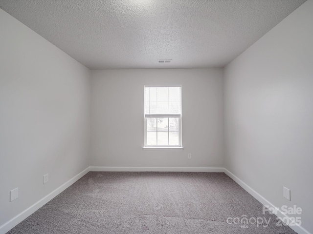 carpeted empty room featuring visible vents, a textured ceiling, and baseboards