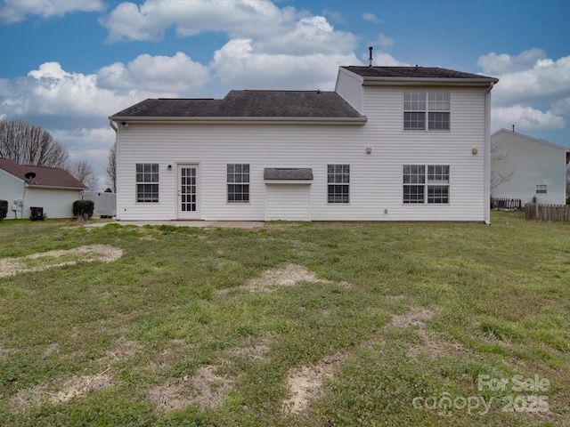 back of house with fence and a yard