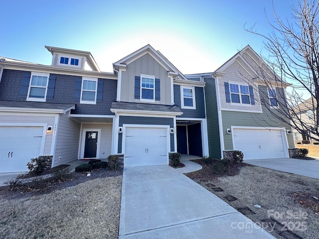 townhome / multi-family property with driveway, an attached garage, and board and batten siding