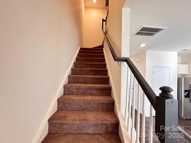 stairway with visible vents and baseboards