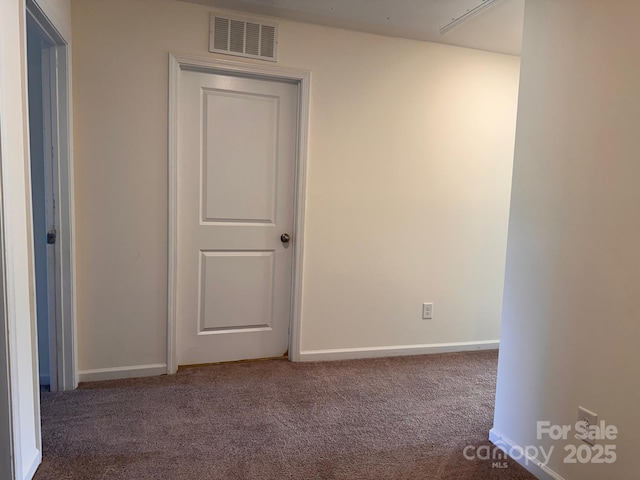 carpeted spare room featuring baseboards and visible vents