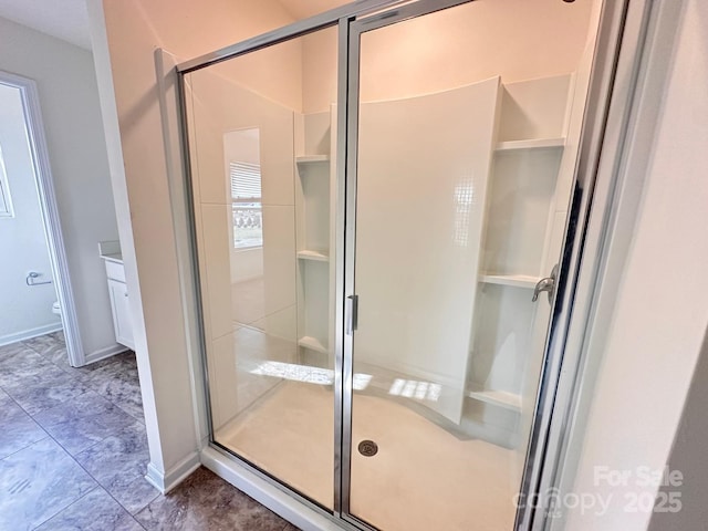 bathroom with a stall shower and baseboards