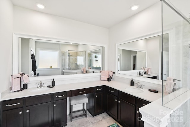 full bathroom featuring double vanity, a stall shower, and a sink