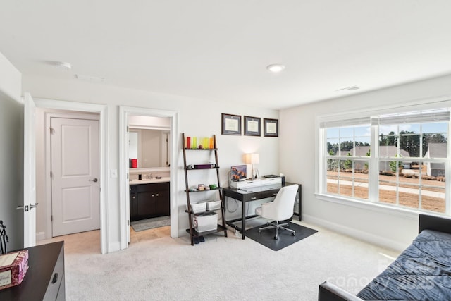 office space with a sink, visible vents, baseboards, and light colored carpet