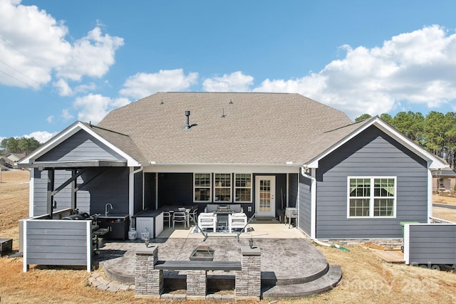 rear view of house featuring a patio, an outdoor living space, and roof with shingles