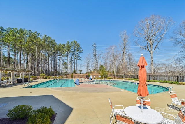 pool with a patio and fence