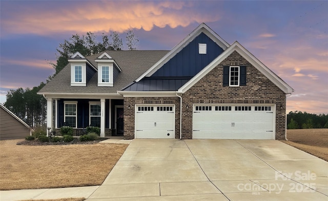 view of front facade featuring a porch, brick siding, board and batten siding, and driveway