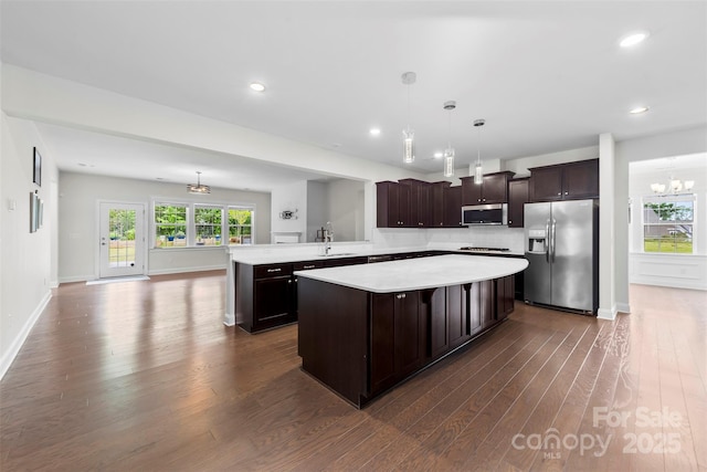 1300 Dali Blvd, Mount Holly, NC 28120 - kitchen with stainless steel appliances, light countertops, dark wood-style flooring, dark brown cabinetry, and a center island