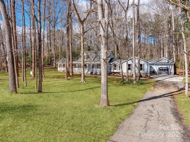 view of front of property with driveway, a garage, a front lawn, and a porch