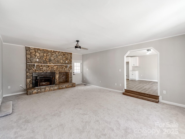 unfurnished living room featuring carpet floors, a fireplace, and crown molding