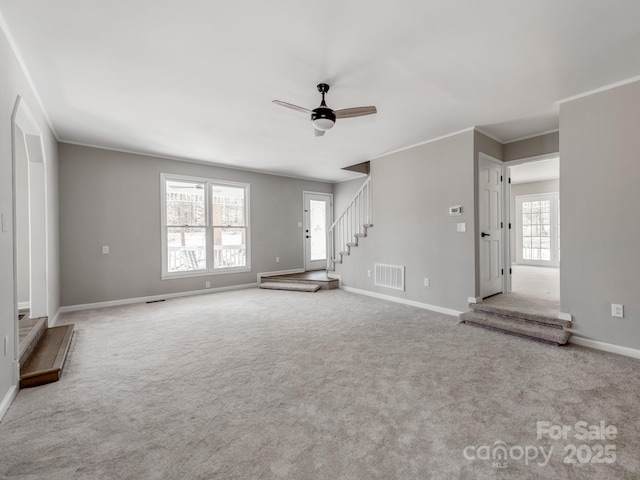 unfurnished living room with carpet, crown molding, visible vents, stairway, and baseboards