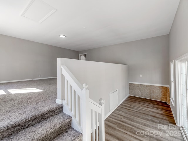 staircase featuring wood finished floors, attic access, and baseboards