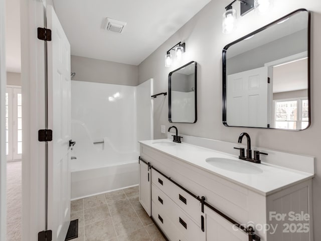 bathroom with shower / tub combination, visible vents, and a sink