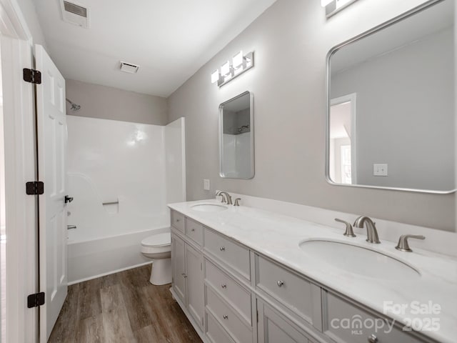 bathroom with visible vents, a sink, and wood finished floors