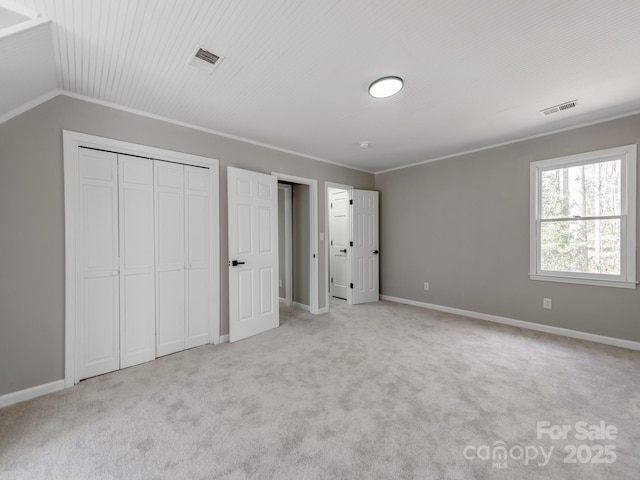 unfurnished bedroom with ornamental molding, light colored carpet, and visible vents