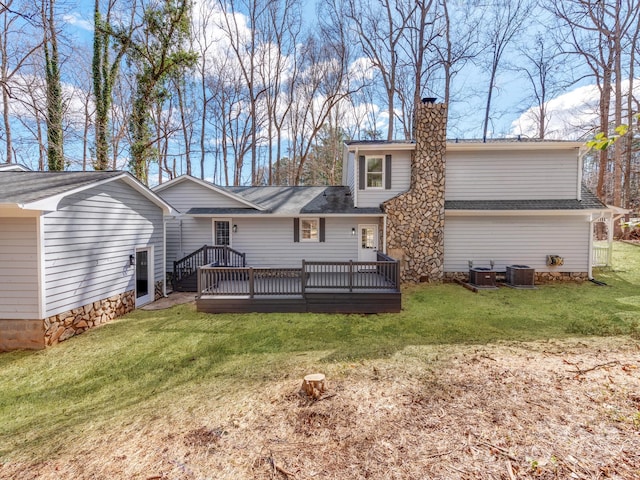 rear view of property with a deck, a yard, a chimney, and central air condition unit