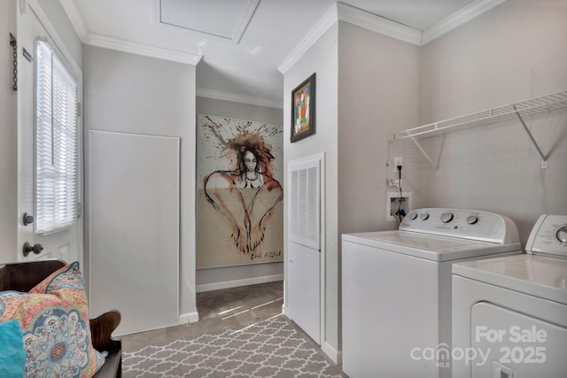 laundry room featuring baseboards, laundry area, separate washer and dryer, and crown molding