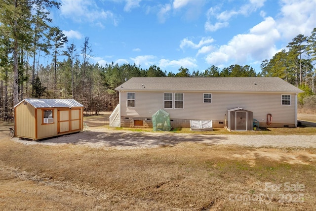 back of property featuring an outbuilding, a shed, and crawl space