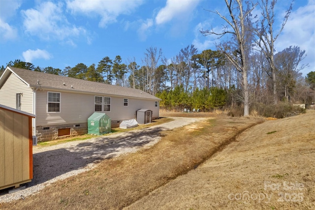 back of house featuring crawl space and driveway