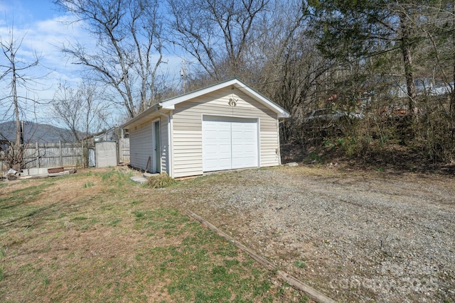 detached garage featuring dirt driveway