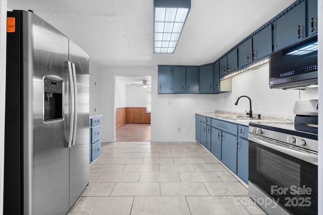 kitchen featuring blue cabinetry, a sink, appliances with stainless steel finishes, light countertops, and ceiling fan