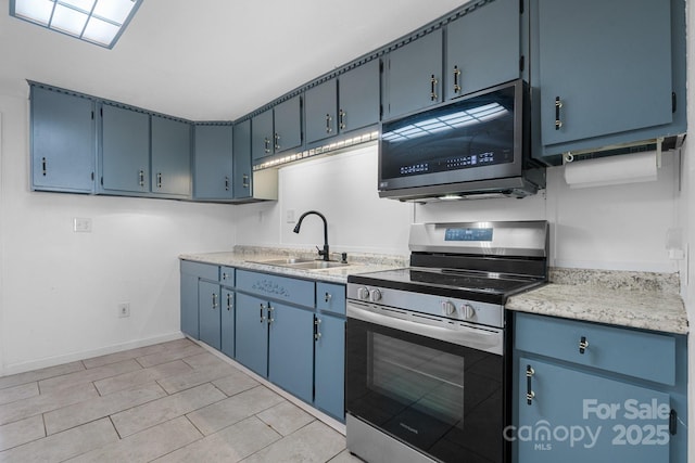 kitchen with blue cabinetry, baseboards, light countertops, appliances with stainless steel finishes, and a sink