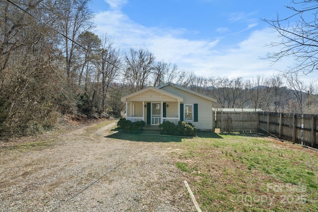 bungalow-style home with fence and covered porch