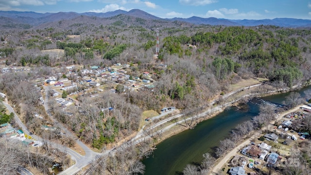 aerial view with a wooded view and a water and mountain view