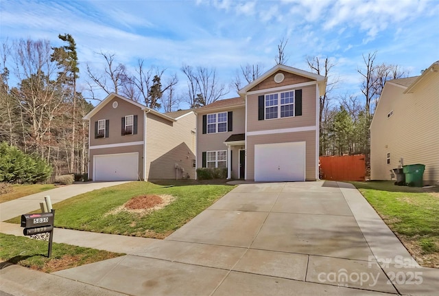 traditional-style house with an attached garage, driveway, fence, and a front yard