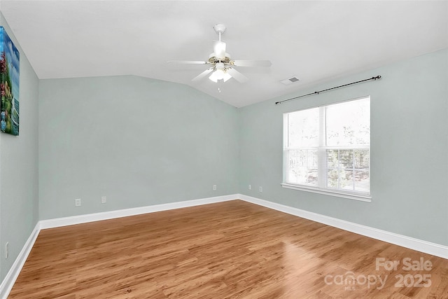 unfurnished room with baseboards, visible vents, a ceiling fan, lofted ceiling, and wood finished floors