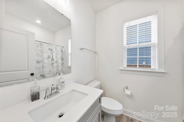 bathroom featuring a wealth of natural light, vanity, toilet, and a shower with curtain