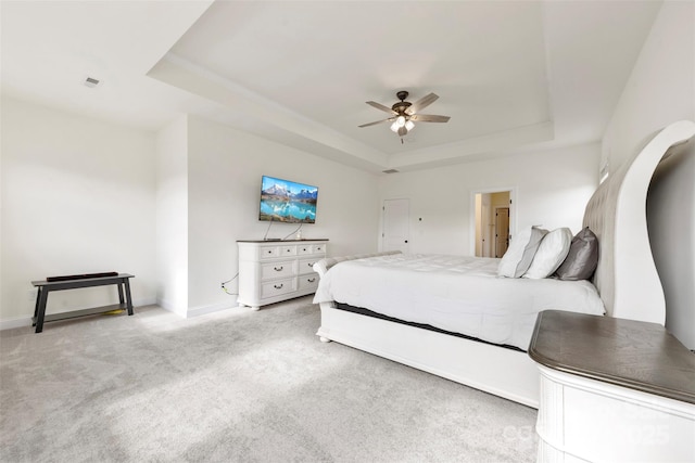 bedroom featuring baseboards, a tray ceiling, and carpet flooring