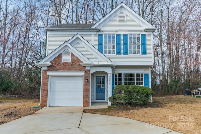 traditional home featuring a garage, concrete driveway, and brick siding