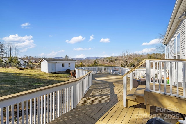 deck with a yard, a mountain view, and an outbuilding