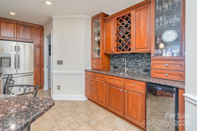 kitchen with brown cabinetry, tasteful backsplash, and stainless steel refrigerator with ice dispenser