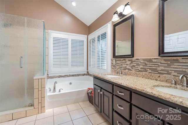 bathroom with a sink, vaulted ceiling, a shower stall, and tile patterned flooring