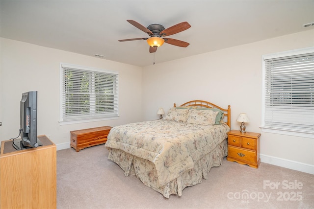 bedroom featuring visible vents, light colored carpet, baseboards, and ceiling fan