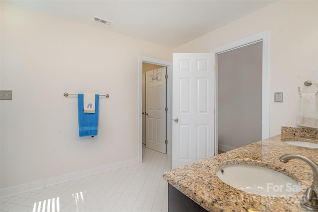 bathroom featuring tile patterned floors, double vanity, visible vents, and a sink