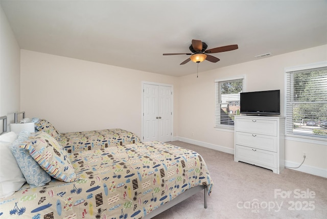 bedroom featuring a ceiling fan, baseboards, visible vents, and light carpet