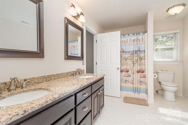 full bath featuring double vanity, toilet, visible vents, and a sink