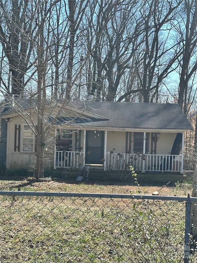 ranch-style home featuring a porch and fence