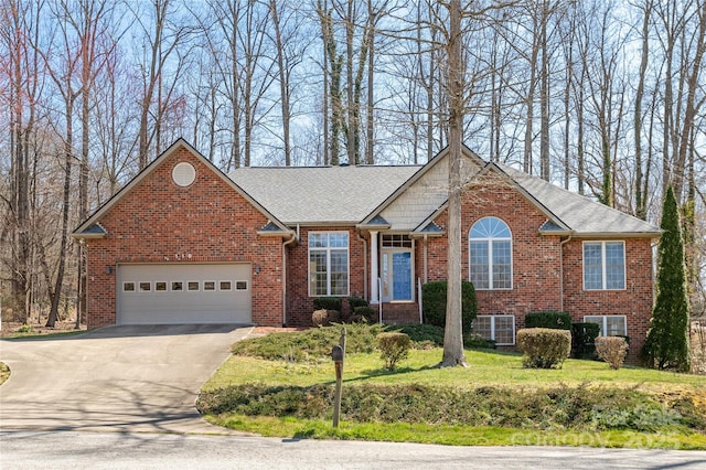 view of front of property with brick siding, an attached garage, driveway, and roof with shingles