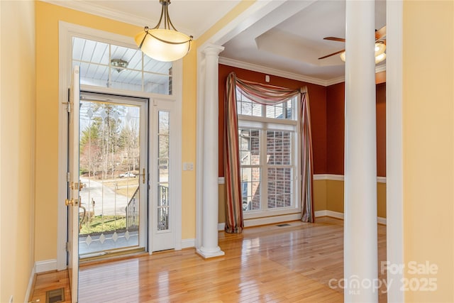 entrance foyer featuring decorative columns, plenty of natural light, visible vents, and hardwood / wood-style floors