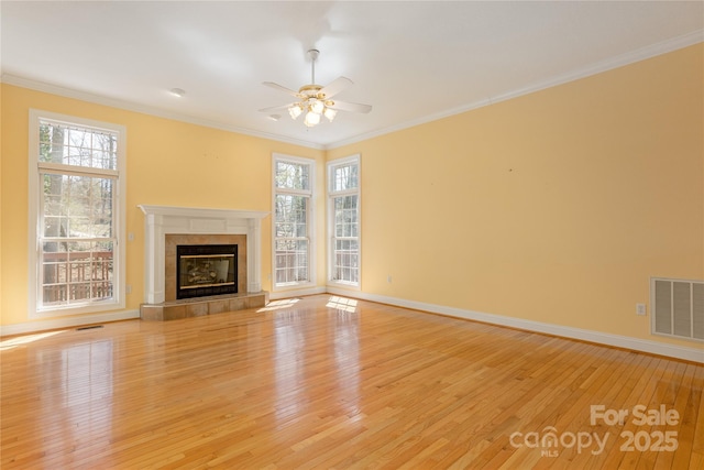 unfurnished living room featuring visible vents, light wood-style flooring, crown molding, and a ceiling fan