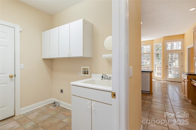 laundry area featuring electric dryer hookup, washer hookup, a sink, cabinet space, and baseboards